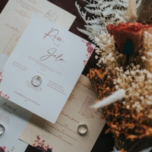 Beautifully designed wedding invitations paired with a rustic bouquet for a natural touch.