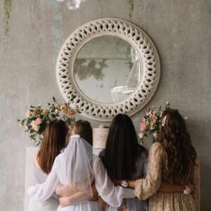 A group of women hugging at a bridal shower with elegant decor. Perfect for wedding themes.