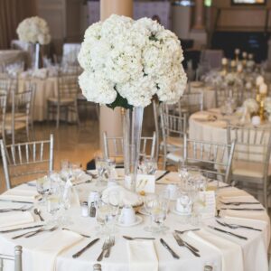 Beautifully decorated wedding reception table with elegant floral centerpiece and silverware.