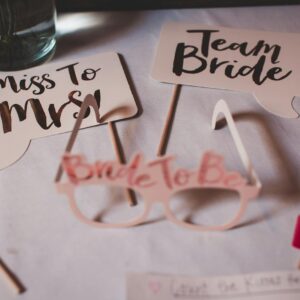 Flat lay of bridal shower decorations with creative signs and props.