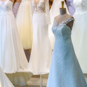 A display of elegant white wedding dresses on mannequins showcasing lace and silk designs.